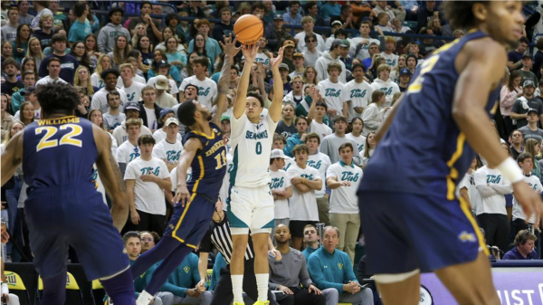 Jenkins shoots three pointer in front of Teal Nation. (Chris Crouch/UNCWSports.com)
